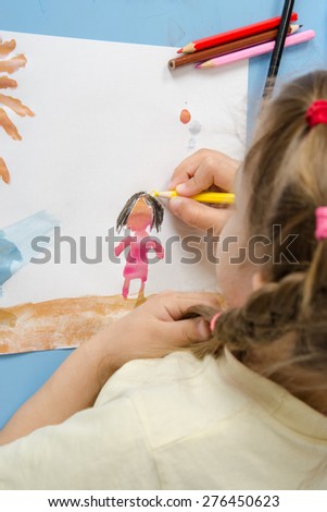 Girl draws a pencil on drawing painted colors