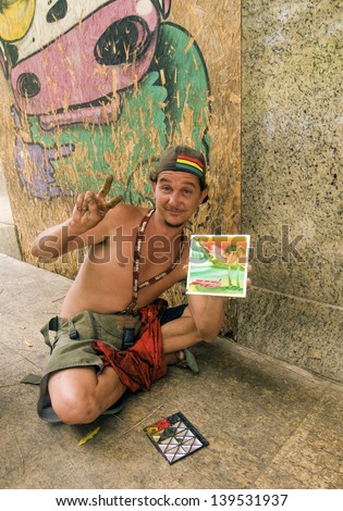 SALVADOR, BRAZIL- DECEMBER 9: Unidentified street artist shows his painted stained fingers used to create his painting on December 9, 2012 in Salvador. Finger painting is a technique used in Bahia.