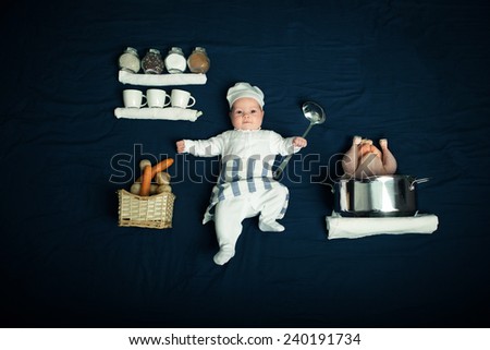 A little chef. A little baby in cook suit with chicken and vegetables on blue background.