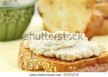Vegan sandwich spread made with a meat substitute for shredded chicken or turkey and tofu mayonnaise. More spread and bread in background.