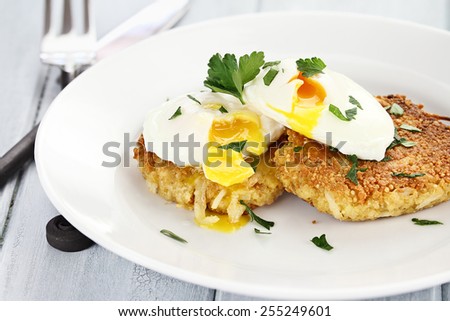 Savory Quinoa and potato pancake patties and poached eggs with shallow depth of field.