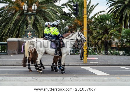 MELBOURNE, AUSTRALIA - November 16, 2014: Victoria Police mounted police officers on St Kilda Road.  Victoria Police mounted officers are often used for crowd control situation, such as protests.