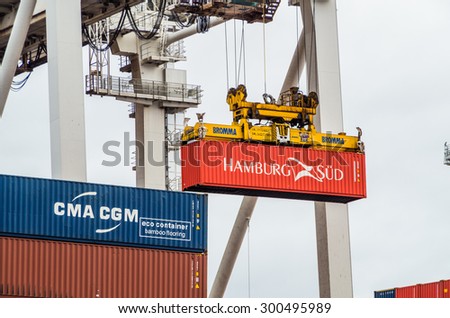 Melbourne, Australia - July 25, 2015: Hamburg Sud container being lifted off a ship at the Port of Melbourne using a crane.