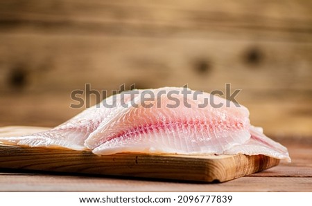 Fresh fish fillet on a cutting board. On a wooden background. High quality photo Сток-фото © 