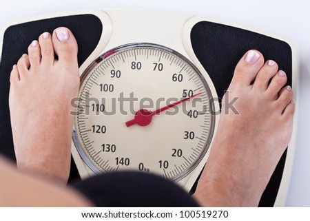 Woman measuring her weight on a balance