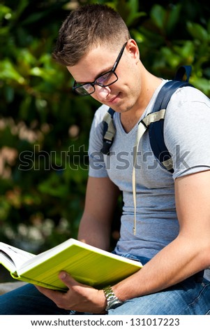 Student reading a book in the park
