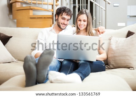 Portrait of a couple using a notebook on the couch