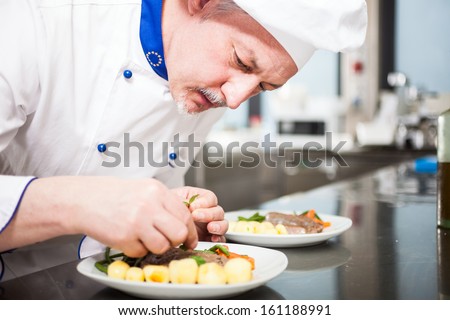 Professional chef garnishing a dish