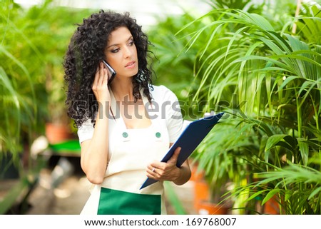 Female researcher talking on the phone in a greenhouse