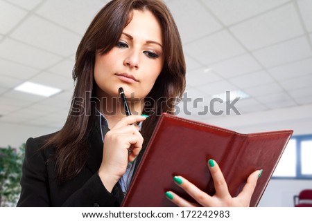 Businesswoman writing notes on her agenda
