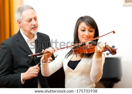 Violin teacher helping a student