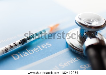Stethoscope and a syringe on a diabetes test