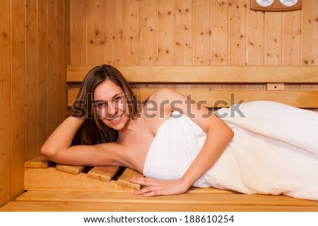 Young woman having a sauna bath in a steam room