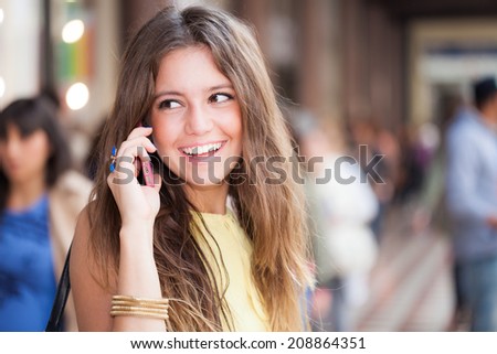 Portrait of a woman talking on the cell phone in a crowded street