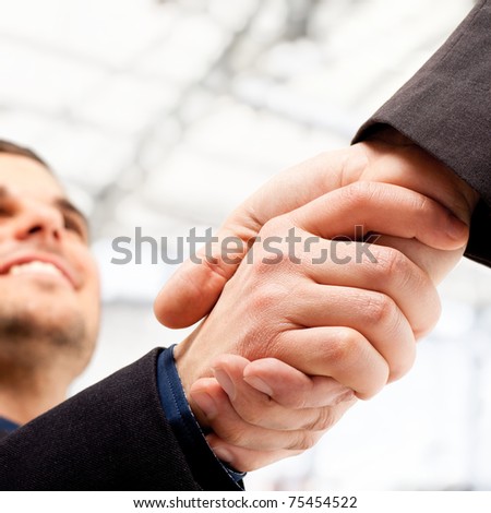 Business people shaking hands. Bright blurred background.