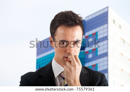Portrait of a meditative young businessman against a blurred skyline background
