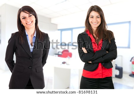 Two businesswoman welcoming you in an office hall