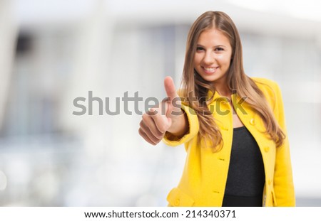 Young woman giving thumbs up. Focus on the thumb