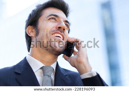 Smiling businessman talking at the phone