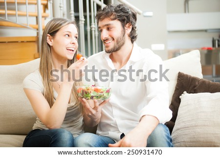Couple eating a salad on the couch