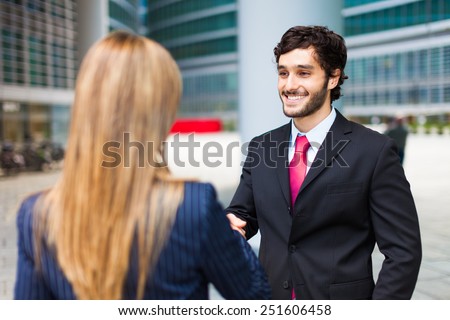 Young smiling business people shaking hands