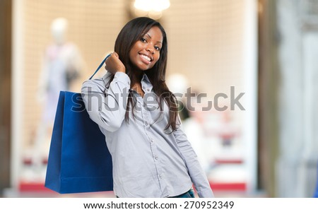 Beautiful black woman smiling and holding shopping bags