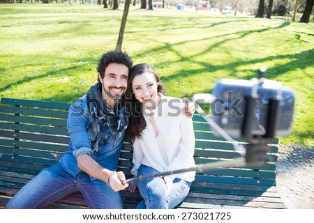 Couple using a selfie stick in a park