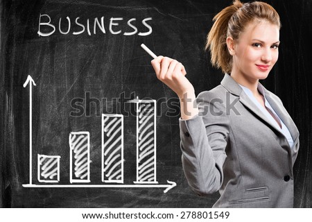 Smiling woman showing a positive business trend on a blackboard