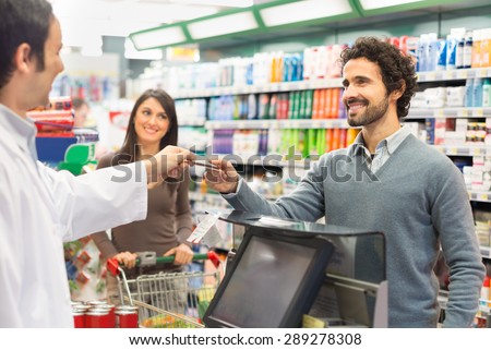 Customer using a credit card to pay in a supermarket