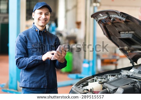 Portrait of a mechanic using a tablet in his garage