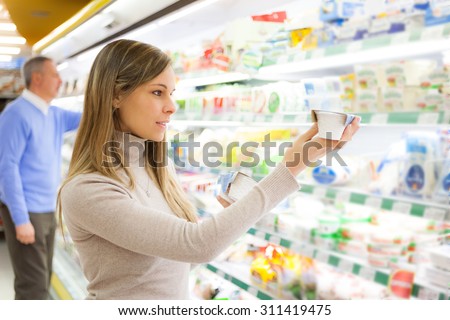 Smiling customer taking a product in a supermarket