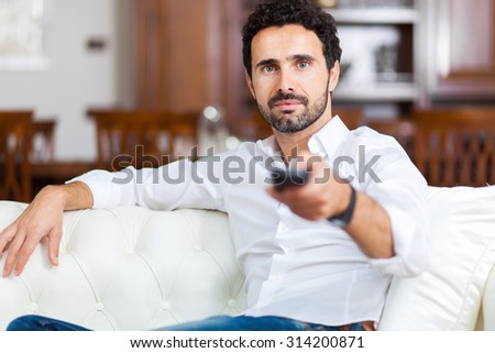 Portrait of a man choosing a program to watch on television