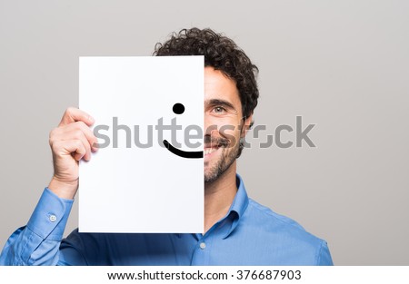 Photo of Happy man covering half his face with a smiling emoticon