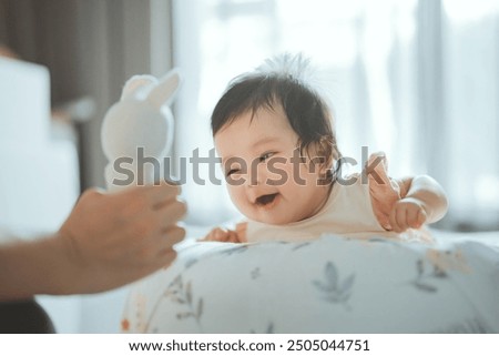 Similar – Image, Stock Photo Cute baby infant crawling away from their parents, that are sitting in the background. Baby looks at camera.