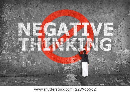 businesswoman drawing negative thinking on the wall