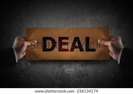 Hand holding sign deal on paper