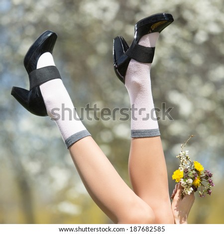 Sexy woman legs in shoes on spring park background. Spring vacation concept