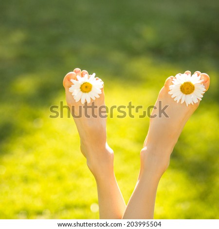 Girl lying on grass in summer park with legs up. Summer vacation concept. soft backlight