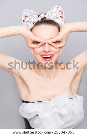 Fashion woman make funny grimace with hands near face. Cute woman making a funny face