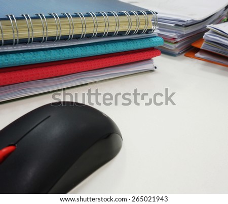 Set of documents on the desk and black computer mouse placed on the side.