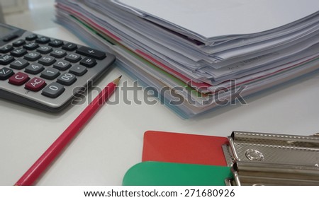 Pile of paperwork  and office supply placed on table in workplace.