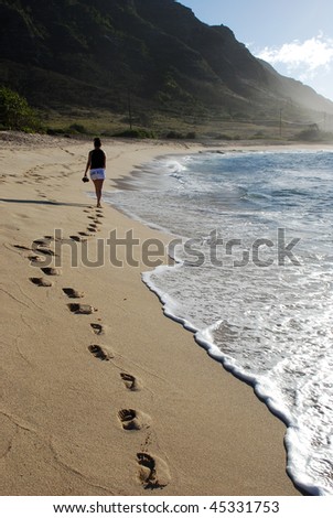 Woman walking along beach.