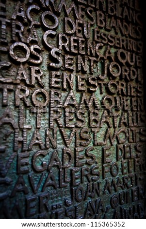 BARCELONA, SPAIN - APRIL 21, 2010 Pattern of bronze raised letters covered with green patina on wall plaque in Sagrada Familia the # 1 tourist spot in Barcelona on April 21, 2010 in Barcelona, Spain.