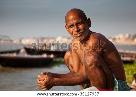 VARANASI, INDIA - JULY 22: Man bathe at the edge of the Ganges after a solar eclipse taking advantage of the river\'s purifying powers on the auspicious day July 22, 2009 in Varanasi, India.