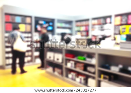 People shopping in gadget shop in department store.