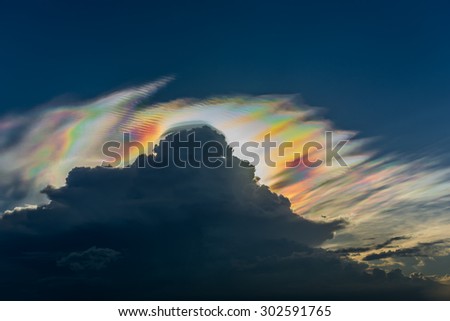 Cloud iridescence behind dark rain cloud : diffraction phenomenon produce very vivid color and make cloud shine like a corona.