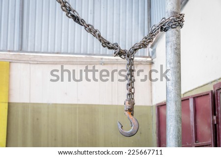 Metal hook hanging on chain in factory