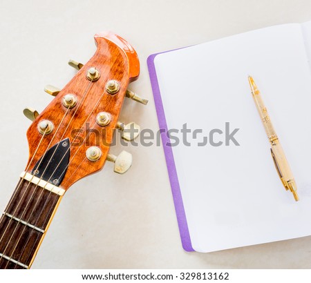 Still life art photography music and memories concept with guitar, notebook, pen and space for write message