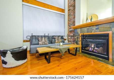 Interior design of a luxury living room with a brick wall and fireplace with a bottle of wine and two glasses