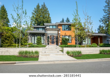 Modern house with wood trim exterior and beautiful landscaping. Home exterior design.